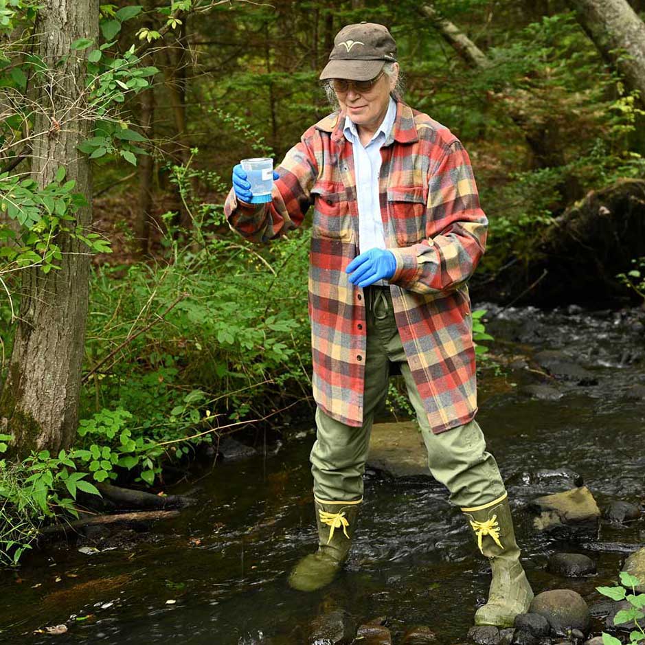 Woman taking a water sample for testing.